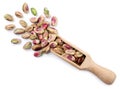 Peeled pistachios in a wooden scoop on a white background, isolated. Top view