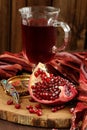 Peeled pomegranate, glass of pomegranate juice and jewerly on wooden board