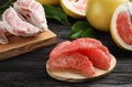 Peeled pomelo slices on black wooden table