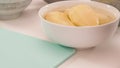 Peeled potato in a bowl close up on white kitchen table Royalty Free Stock Photo