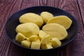 Peeled potatoes in a bowl on wooden table Royalty Free Stock Photo