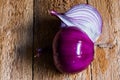 Peeled purple onion cut in half, on weathered wood background Royalty Free Stock Photo