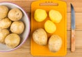 Peeled raw potatoes on cutting board, glass bowl Royalty Free Stock Photo