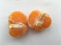 Peeled ripe pitted mandarin. Minimalistic still life on a white background.