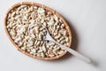 Peeled salted peanuts in wicker basket and wooden spoon on beige Royalty Free Stock Photo