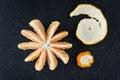 Peeled and sectioned fresh orange on a black cutting board