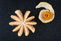 Peeled and sectioned fresh orange on a black cutting board