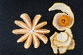 Peeled and sectioned fresh orange on a black cutting board