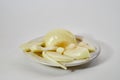 Peeled and sliced fresh onion bulbs on plate on white background Royalty Free Stock Photo