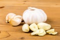 Peeled and sliced garlic cloves with whole garlic bulb and cloves as background