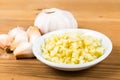 Peeled and sliced garlic cloves with whole garlic bulb and cloves as background