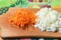 Peeled and sliced onions and carrots at the stage of preparation of dishes