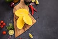 Peeled sliced Tropical mango fruit on a wooden cutting board