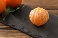 Peeled tangerine on wooden table, healthy food concept