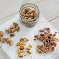 Peeled and unpeeled pistachio nuts presented on a white napkin