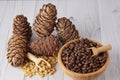 Peeled and unrefined pine nuts and cedar cones on a wooden table Royalty Free Stock Photo