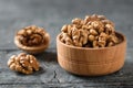 Peeled walnut in a wooden bowl on a dark wooden table