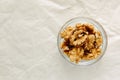 Peeled walnuts in round bowl, close-up, on light background. View from above. Royalty Free Stock Photo