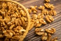 Peeled walnuts in a wicker basket and peeled walnuts scattered on a wooden table. Healthy diet. Fitness diet. Close up Royalty Free Stock Photo