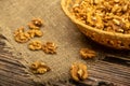 Peeled walnuts in a wicker basket and peeled walnuts scattered on a wooden table covered with rough-textured burlap. Healthy diet Royalty Free Stock Photo