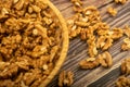 Peeled walnuts in a wicker basket and peeled walnuts scattered on a wooden table. Healthy diet. Fitness diet. Close up. Royalty Free Stock Photo