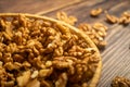 Peeled walnuts in a wicker basket and peeled walnuts scattered on a wooden table. Healthy diet. Fitness diet. Close up Royalty Free Stock Photo