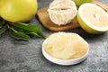 Peeled yellow pomelo slices on grey table