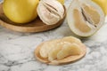 Peeled yellow pomelo slices on white marble table