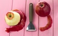 Peeler for cleaning fruits and vegetables with red apples and with peeled skin
