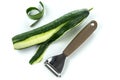 Peeler for cleaning vegetables and fruits with cucumber with peeled skin.
