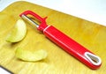 Peeler for cleaning vegetables and fruits from the skin. Apple with peeled skin.