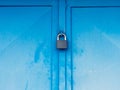 Peeling blue paint door. Rusty dotted metal door with retro style padlock Royalty Free Stock Photo