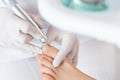 Peeling feet with special electric device.Professional hardware pedicure using electric machine.Patient on medical Royalty Free Stock Photo