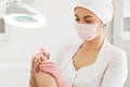 Peeling feet with special electric device.Professional hardware pedicure using electric machine.Patient on medical Royalty Free Stock Photo