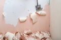 Peeling old latex paint off the wall. Using a scraper to renovate a bathroom Royalty Free Stock Photo