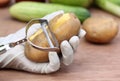 Peeling potato in kitchen Royalty Free Stock Photo