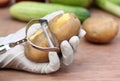 Peeling potato in kitchen