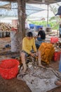 Peeling and scraping the coconut in factory for burning.