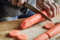 Peeling and slicing carrots close up. Girly hands preparing food