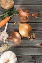 Peeling spicy white onion. Flat lay view. Fresh raw vegetables and flavorings. Rinding onion on kitchen wooden table. Royalty Free Stock Photo