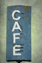 Blue Cafe Sign on Green Background: