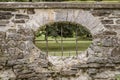 Peep hole with iron bars on a stone fence Royalty Free Stock Photo