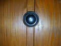 peephole on a wooden door close up photo.