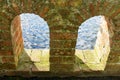 Peeping through a brick archway into view of water