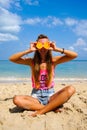 Pefect Vacation. Summer travel. Young beautiful funny model holding orange in front eyes with smile relaxing on the