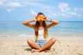 Pefect Vacation. Summer travel. Young beautiful funny model holding orange in front eyes with smile relaxing on the