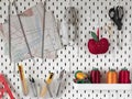 Pegboard with sewing supplies for tailor. White board for accessories storage Royalty Free Stock Photo