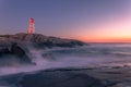 Peggy\'s Cove Lighthouse Atlantic Coast Nova Scotia Canada as the ocean waves pound the rugged shore.