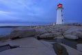 PeggyÃ¢â¬â¢s Cove Lighthouse illuminated at sunset with dramatic waves on the foreground, Nova Scotia