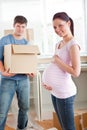 Pegnant woman with husband holding cardboard